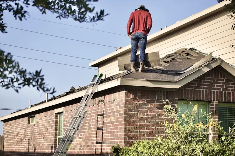 Professional roofer working on a residential roof in Fairknoll